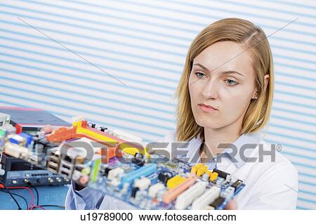Stock Image - Female electrical engineer working in lab. Fotosearch