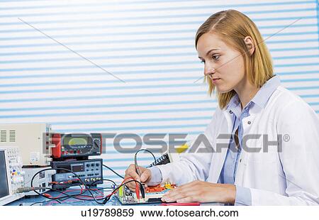 Stock Photo - Female electrical engineer working in lab. Fotosearch