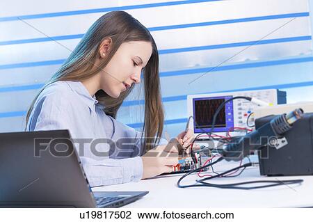 Stock Image - Female electrical engineer working. Fotosearch