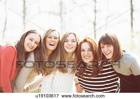 Female friends in a huddle side by side looking at camera smiling View Large Photo Image Stock Photo - Female friends in a huddle side by side looking at camera smiling. Fotosearch