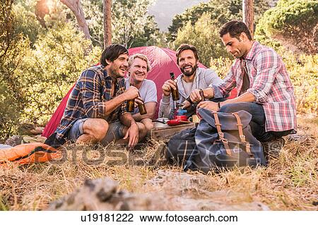 Four male friends relaxing with beer bottles in forest camp, Deer Park, Cape Town, South Africa View Large Photo Image Stock Image - Four male friends relaxing with beer bottles in forest camp, Deer Park, Cape Town, South Africa. Fotosearch