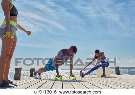 Friends on pier using exercise equipment View Large Photo Image Stock Photograph - Friends on pier using exercise equipment. Fotosearch
