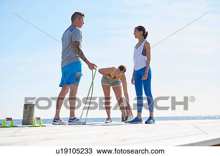 Friends wearing sports clothes on pier with skipping rope View Large Photo Image Stock Image - Friends wearing sports clothes on pier with skipping rope. Fotosearch