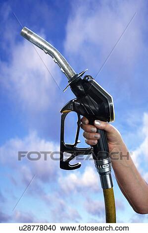 Stock Image - Fuel pump nozzle held in a hand. Fotosearch