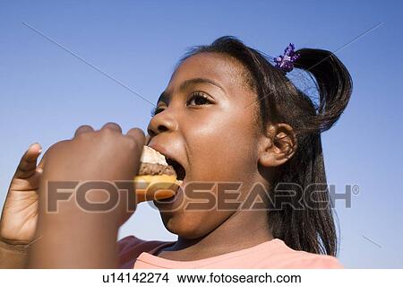 Picture - Girl eating a burger. Fotosearch