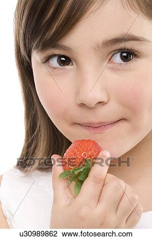 Stock Image - Girl eating a strawberry. Fotosearch