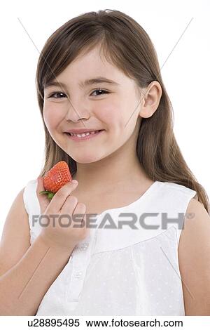 Stock Photography - Girl eating a strawberry. Fotosearch
