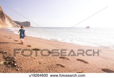 Stock Image - Girl enjoying beach, Man O'War Beach, Dorset. Fotosearch