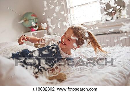 Girl falling on feather pillow fight bed View Large Photo Image Stock Image - Girl falling on feather pillow fight bed. Fotosearch