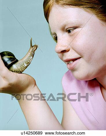 Stock Photo - Girl holding a giant snail. Fotosearch