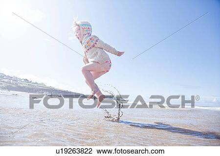 Girl jumping in water, Polzeath Beach, Cornwall View Large Photo Image Stock Image - Girl jumping in water, Polzeath Beach, Cornwall. Fotosearch