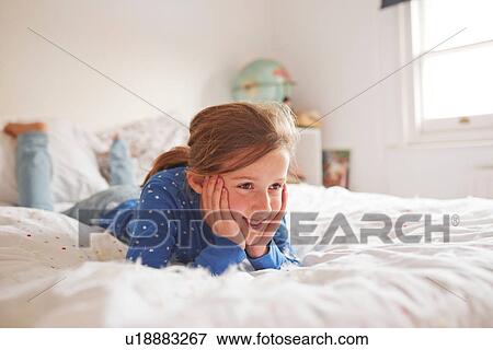 Girl lying on bed covered in white feathers View Large Photo Image Stock Photo - Girl lying on bed covered in white feathers. Fotosearch