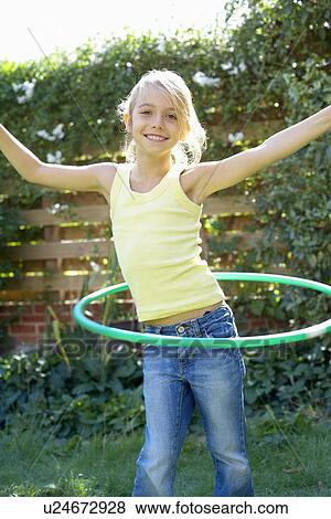 Stock Photo - Girl playing with a hula hoop. Fotosearch