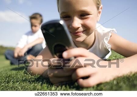 Girl using a mobile phone View Large Photo Image Stock Image - Girl using a mobile phone. Fotosearch