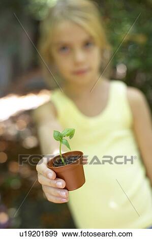 Stock Photo - Girl with a pot plant. Fotosearch