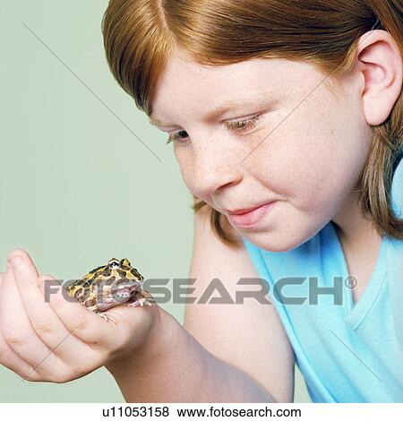 Stock Photo - Girl with her pet toad. Fotosearch