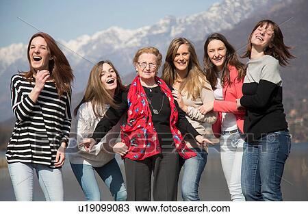 Grandmother with granddaughters in front of snow capped mountains looking at camera smiling View Large Photo Image Stock Image - Grandmother with granddaughters in front of snow capped mountains looking at camera smiling. Fotosearch