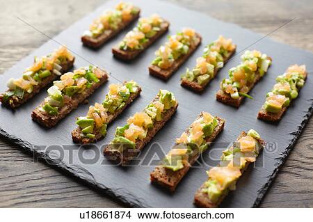 Picture - Guacamole, smoked salmon and rye bread canapes. Fotosearch