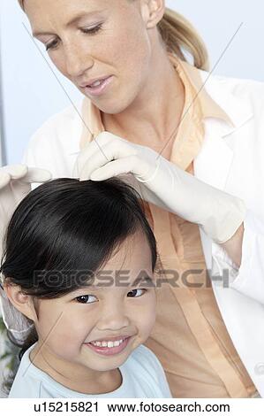 Stock Image - Head lice examination. Fotosearch