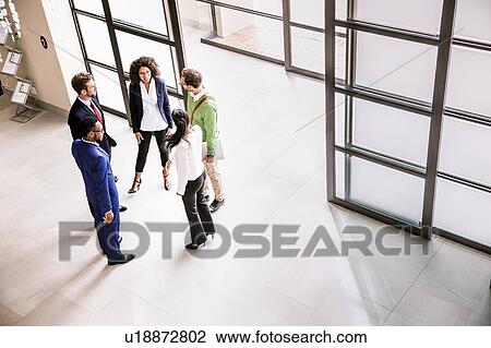 High angle view of businessmen and women talking at office entrance View Large Photo Image Stock Image - High angle view of businessmen and women talking at office entrance. Fotosearch
