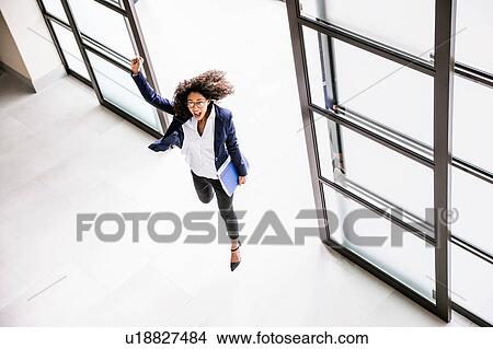 High angle view of businesswoman running through office entrance View Large Photo Image Picture - High angle view of businesswoman running through office entrance. Fotosearch