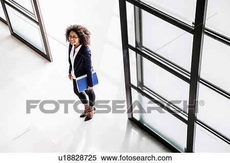 High angle view of businesswoman arriving in office entrance View Large Photo Image Stock Photography - High angle view of businesswoman arriving in office entrance. Fotosearch