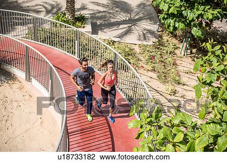 High angle view of running couple running up footbridge, Dubai, United Arab Emirates View Large Photo Image Stock Image - High angle view of running couple running up footbridge, Dubai, United Arab Emirates. Fotosearch