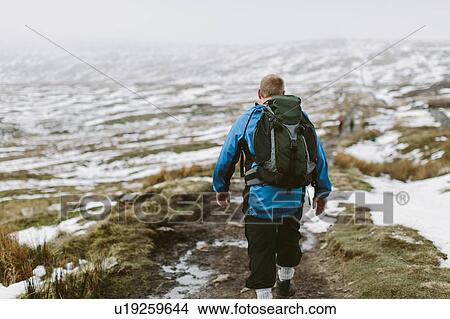 Hiker crossing snow-covered moor, Yorkshire Dales National Park, England View Large Photo Image Picture - Hiker crossing snow-covered moor, Yorkshire Dales National Park, England. Fotosearch
