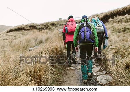 Stock Image - Hikers crossing moor, Yorkshire Dales National Park, England. Fotosearch