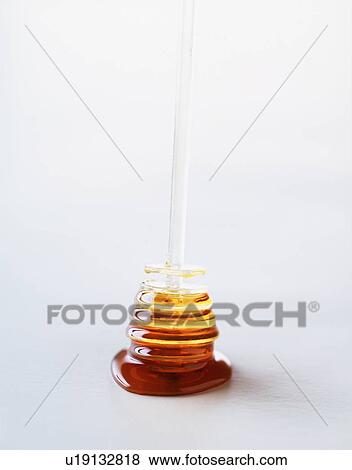 Stock Photo - Honey on honey dipper, close-up. Fotosearch