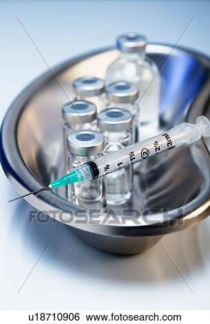 Stock Photograph - Injectable medications. Kidney dish with injectable medications in sealed vials and a disposable plastic medical syringe. Fotosearch