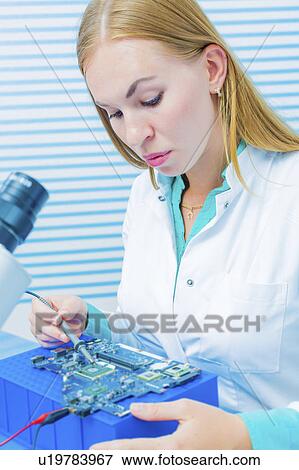 Lab assistant testing printed circuit View Large Photo Image Stock Photo - Lab assistant testing printed circuit. Fotosearch