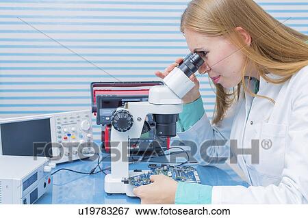 Stock Photo - Lab assistant using microscope. Fotosearch