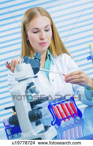Picture - Lab assistant using pipette. Fotosearch