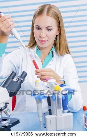 Stock Photograph - Lab assistant using pipette. Fotosearch