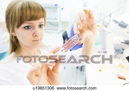 Stock Photograph - Lab technician holding a lab on a chip. Fotosearch