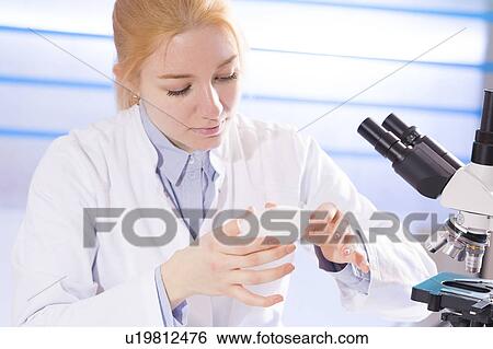 Stock Photograph - Lab technician holding a petri dish. Fotosearch