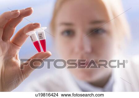 Picture - Lab technician holding eppendorf tubes. Fotosearch