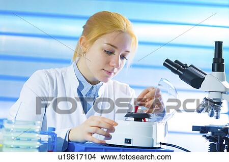 Picture - Lab technician holding sample in lab. Fotosearch
