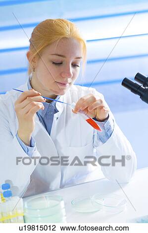 Stock Image - Lab technician holding test tube. Fotosearch