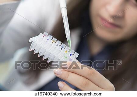 Stock Image - Lab technician holding test tubes. Fotosearch