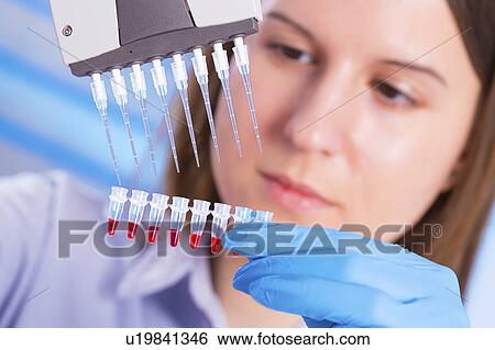 Stock Photograph - Lab technician using micro pipette. Fotosearch