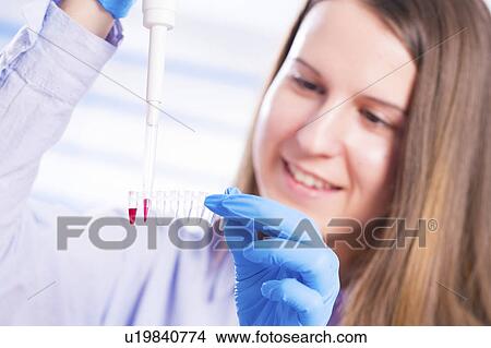 Picture - Lab technician using pipette. Fotosearch
