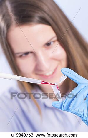 Stock Image - Lab technician using pipette. Fotosearch