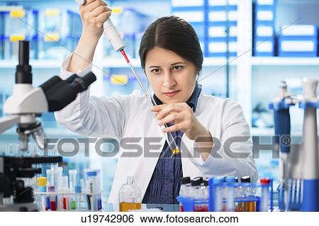 Stock Photograph - Lab technician using pipette. Fotosearch