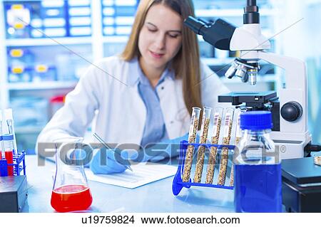 Picture - Lab technician writing notes. Fotosearch