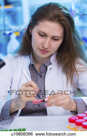 Stock Photograph - Lab technician writing on a sample. Fotosearch
