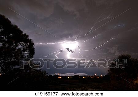 Stock Photo - Lightning seems to explode from one point into a spider, lighting up the sky in Rockledge, Florida, USA. Fotosearch