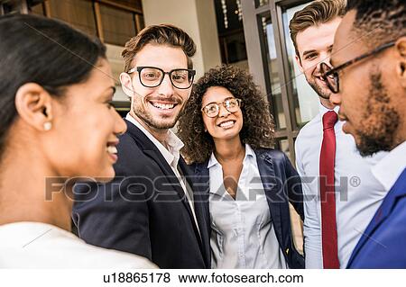 Stock Photo - Male and female business team talking outside office. Fotosearch