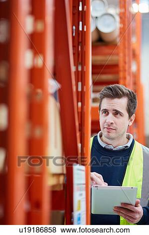 Male factory worker using digital tablet in factory warehouse View Large Photo Image Stock Photo - Male factory worker using digital tablet in factory warehouse. Fotosearch